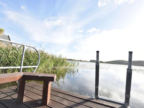 a bench sitting on a dock next to a body of water at Ferienhaus mit Kamin in Sternberg in Sternberg