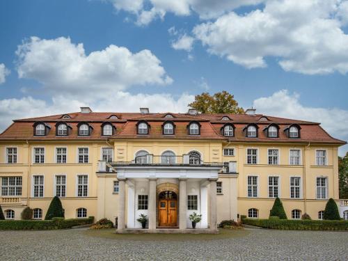 a large yellow building with a red roof at Apartment in Warin in der N he des Glammsees in Warin
