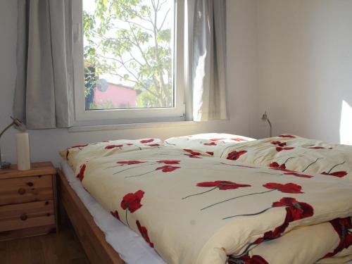HohenkirchenにあるVibrant holiday home in Lucca with private poolのベッドルーム1室(赤い花のベッド1台付)