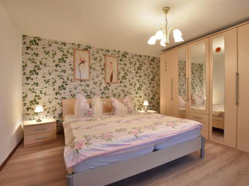 ボルテンハーゲンにあるClassy Apartment in Boltenhagen with Terraceの花柄の壁紙を用いたベッドルーム1室(大型ベッド1台付)