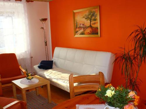 ein Wohnzimmer mit einem weißen Sofa und orangefarbenen Wänden in der Unterkunft Gorgeous Apartment in Wei ig Saxony with garden in Weißig