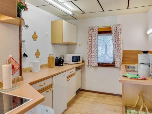 SchmogrowにあるHoliday home in the forestの白いキャビネットと窓付きのキッチン