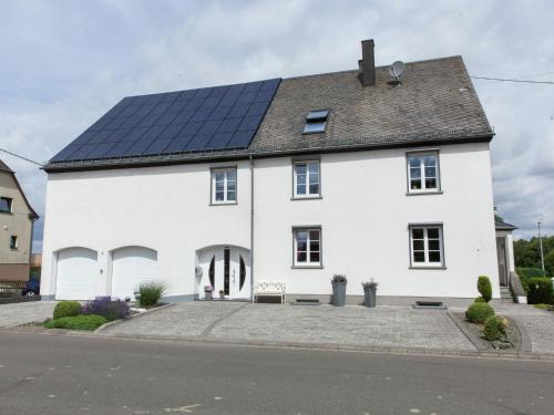 a white house with solar panels on the roof at Beautiful Apartment in Morscheid Riedenburg in Morbach