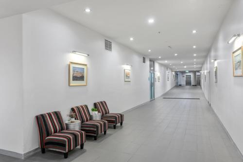 a hallway with chairs in a hospital hallway at Tweed Ultima Apartments in Tweed Heads