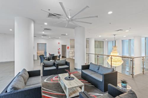 a living room with couches and a table at Tweed Ultima Apartments in Tweed Heads