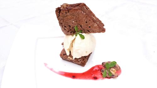 a piece of chocolate cake and a strawberry on a plate at Hotel Tres Banderas in Manuel Antonio