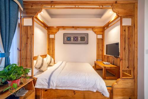 a bedroom with a bed and a tv at Zhangjiajie National Park Yuelu Homestay in Zhangjiajie