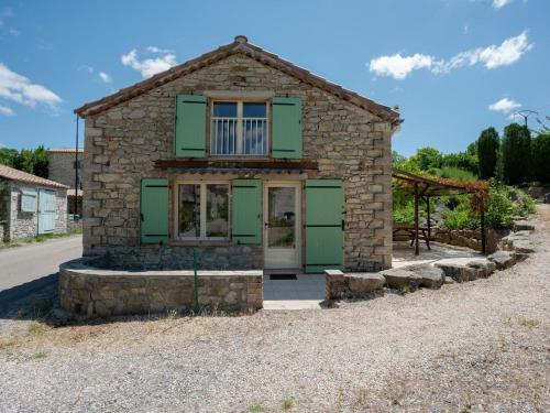 a small stone house with green doors on a street at Pretty Holiday Home in Courry with Swimming Pool in Courry