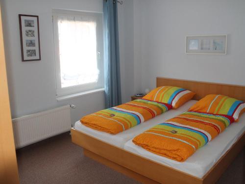 ヴィスマールにあるModern Apartment with Terrace in Wismarのベッドルーム1室(カラフルな枕付きのベッド2台付)