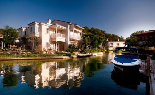 a boat is docked on a river with houses at Portvillas by Villa Safiya in Göcek