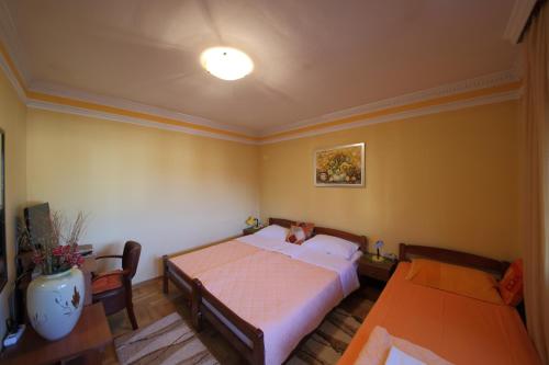 a bedroom with a bed and two tables in it at Guest House Pansion 10 in Cetinje