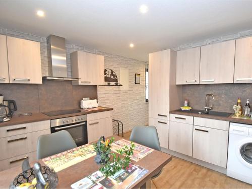 a kitchen with white cabinets and a table with chairs at Holiday flat in Ernstroda near a ski resort in Friedrichroda