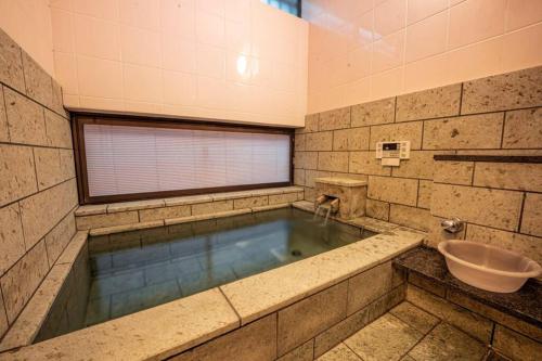 - une piscine d'eau dans la salle de bains pourvue d'un lavabo dans l'établissement むっくのおうち, à Itō