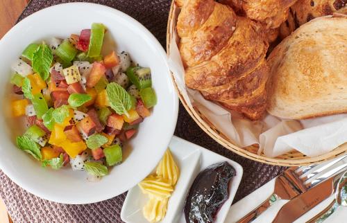 een kom salade naast een mandje brood bij Temple Tree Resort in Pantai Cenang