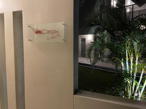 a sign on a wall next to a plant at HALE恩納村 Ys Casa in Onna