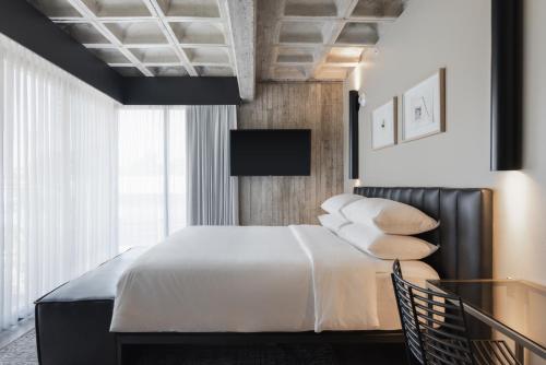 een slaapkamer met een bed met witte lakens en kussens bij Bellwort Hotel in Guadalajara