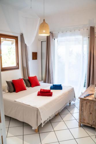 a bedroom with two beds with red and blue pillows at Bungalow Anse Figuier in Terre-de-Haut