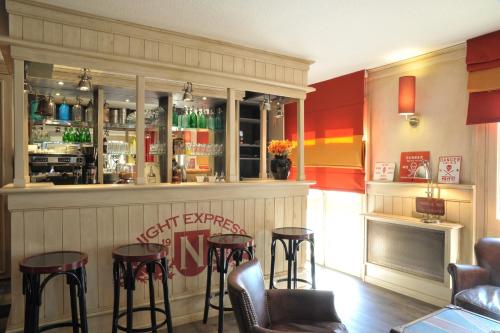 a bar in a restaurant with stools at Brit Hotel Essentiel Cholet in Cholet