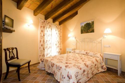 a bedroom with a bed and a chair at Hotel Rural El Pilaret in Azanúy