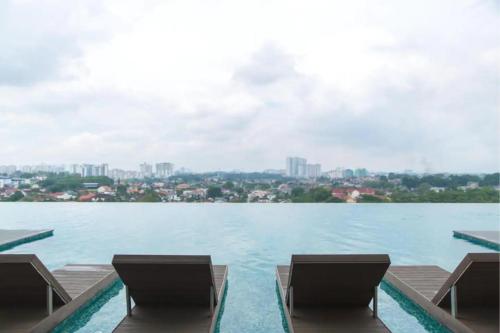 una vista de un gran cuerpo de agua con dos sillas en 1 Tebrau Residences By JK Home, en Johor Bahru