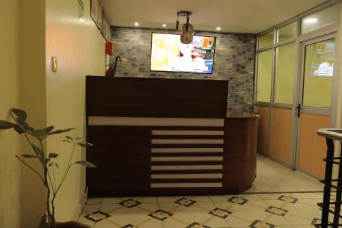 a living room with a wall mounted television at KIMA HILLS HOTEL in Nairobi