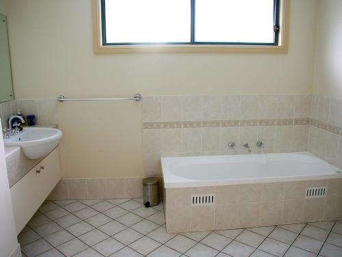 a bathroom with a tub and a sink at Family Beach Retreat in Lovely Terrigal Home in Terrigal