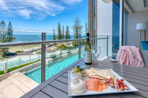 a plate of food on a balcony with a view of the ocean at Oceans Mooloolaba in Mooloolaba