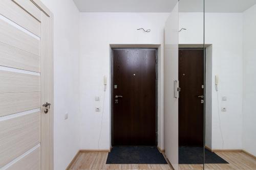 a hallway with two brown doors and a mirror at New Avrora in Novosibirsk