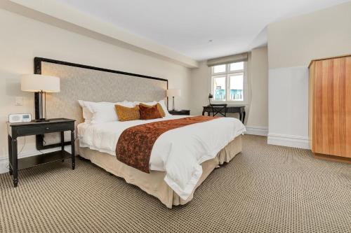 a large bedroom with a large bed and a window at The National Hotel in Fremantle