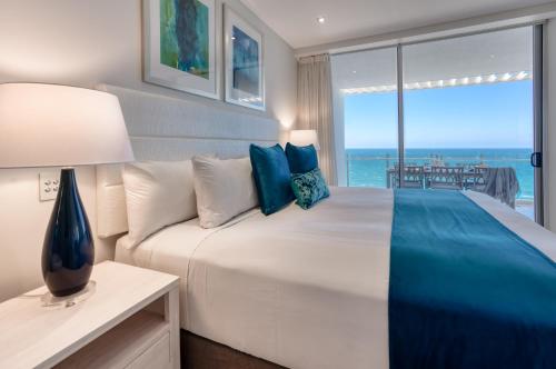 a bedroom with a large bed with a view of the ocean at Oceans Mooloolaba in Mooloolaba