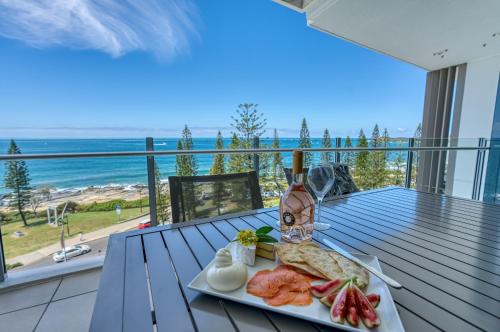 a plate of food on a table with a view of the ocean at Oceans Mooloolaba in Mooloolaba