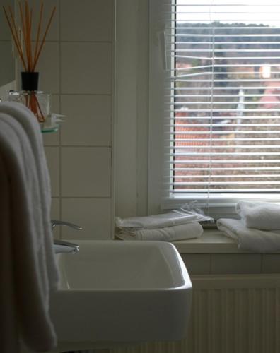 a bathroom with a sink and a window and towels at Hotel & Restaurant Bergschlösschen in Buckow
