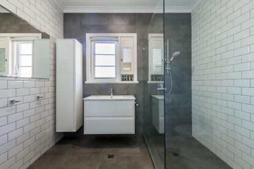 a bathroom with a sink and a glass shower at UrbanStyle Claremont Apartment in Perth