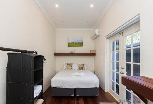 a small bedroom with a bed and a window at UrbanStyle Claremont Apartment in Perth