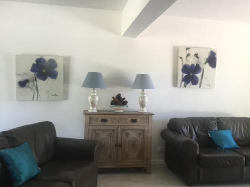 a living room with two couches and a table with two lamps at L’Etang Carp fishing lake and Gite in Saint-Junien