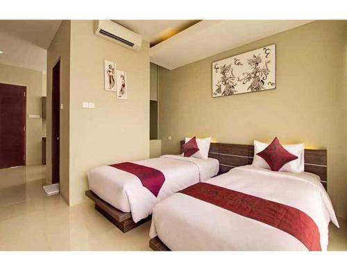 two beds in a hotel room with at ABISHA Resort Jimbaran in Jimbaran