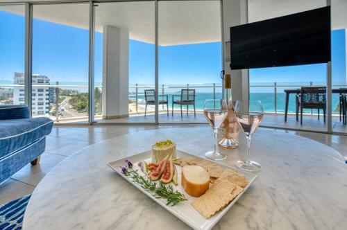 a table with a plate of food and wine glasses at Oceans Mooloolaba in Mooloolaba