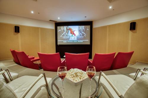a room with red chairs and two glasses of wine at Oceans Mooloolaba in Mooloolaba