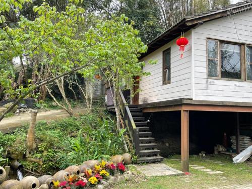 a house with a bunch of flowers in front of it at 山板樵愛面子民宿 in Sanyi