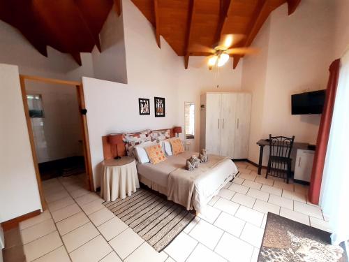 a bedroom with a bed and a table in it at Tatenda Guest House in Hazyview