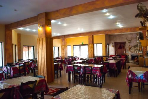 un comedor con mesas y sillas en un restaurante en Hotel Gigilos Omalos, en Omalos