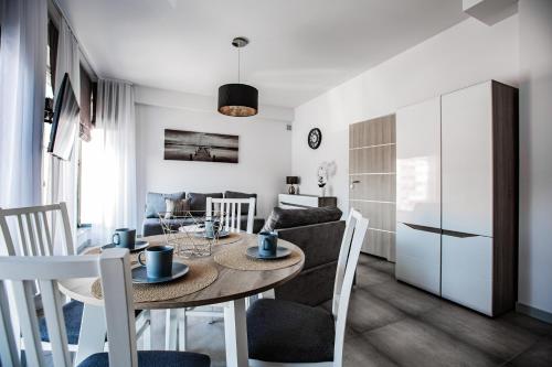a kitchen and living room with a table and chairs at Apartamenty Ola in Lębork