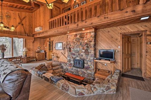 a living room with a large couch and a stone wall at Eagles Nest - Baraboo Cabin on Wisconsin River! in Baraboo