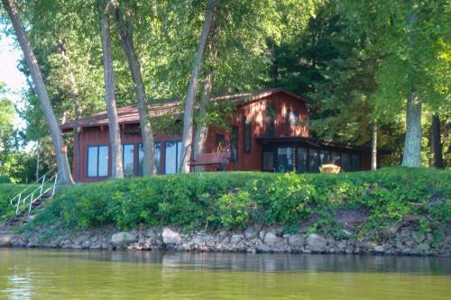 a house on an island next to a body of water at Eagles Nest - Baraboo Cabin on Wisconsin River! in Baraboo