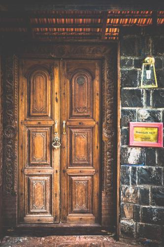 an old wooden door on a brick wall at Ramsukh Resorts and Spa in Mahabaleshwar