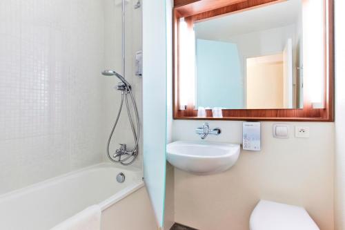 a bathroom with a sink and a toilet and a mirror at Campanile Marne la Vallée - Bussy Saint-Georges in Bussy-Saint-Georges