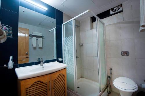 a bathroom with a sink and a shower and a toilet at Imperial Apartment Fortis in Gurgaon