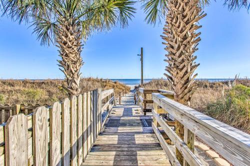 a wooden pathway to the beach with palm trees at Oceanfront Luxury Condo in North Myrtle Beach in Myrtle Beach
