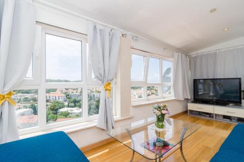 a living room with windows and a tv at Apartment Emma in Dubrovnik