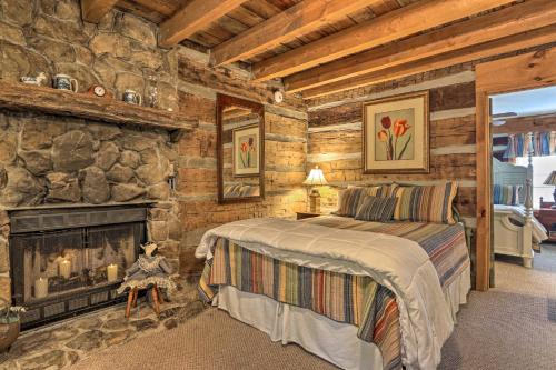 a bedroom with a fireplace in a log cabin at Outdoorsmens Paradise on River with Fire Pit! in Townsend